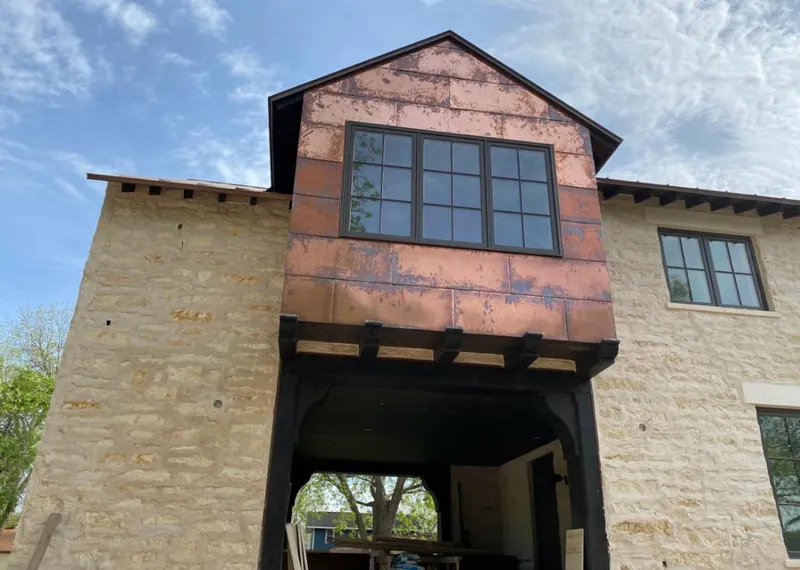 Copper metal panel facade on a stone building for Roof Repair in Richland